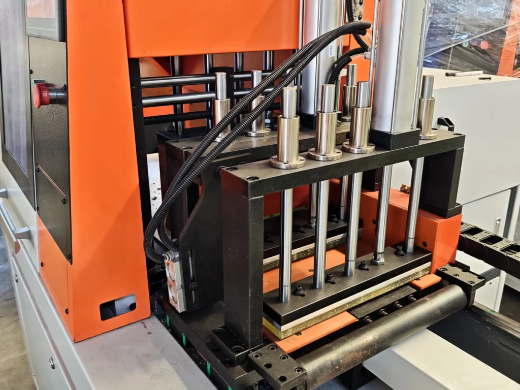 Guide rods, clamp structures and flexible conduits beside an orange aluminum saw, illustrating compressed air quotation context.